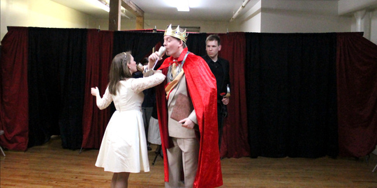 PHOTO: The King (John Walbolt) and Queen (Kitty Mortland) toast their new court, much to Hamlet's (Alex Dabertin) chagrin in Bad Quarto's 2016 production of 		
				<em>Hamlet: The First Quarto</em>, directed by Tony Tambasco. Photo by James M. Smith.